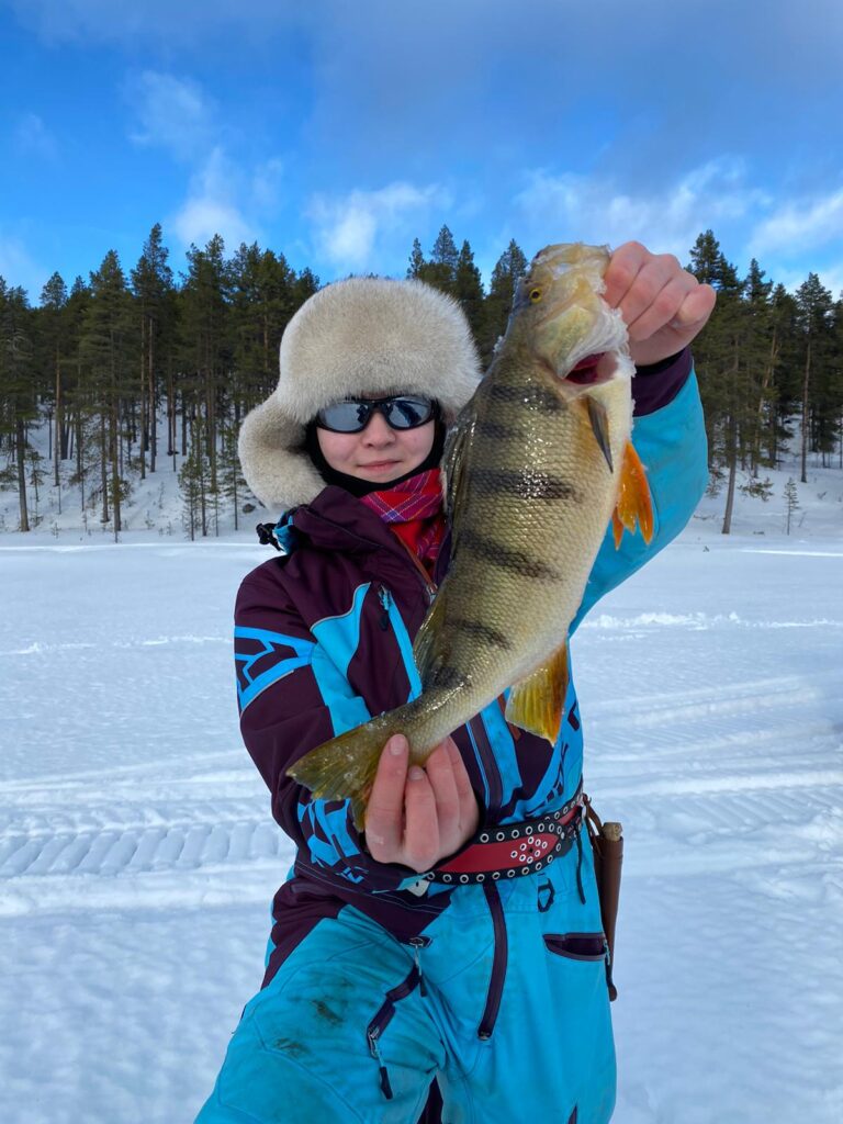 Talvi, tyttö jolla kädessä ahven